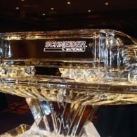 Clear ice sculpture with engraved sign in a dimly lit indoor setting