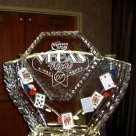 Giant ice sculpted table centerpiece with playing cards and poker chips displayed inside and Vegas Night carved into it.