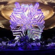 Glowing purple star-shaped holiday ornament with snowflake layers against a warm gold backdrop
