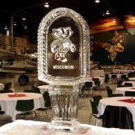 Clear ice sculpture with a Wisconsin mascot in a banquet hall with round tables