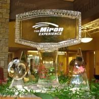 “The Miron Experience” display with gold signage, mirrored spheres, and a colorful floral arrangement indoors