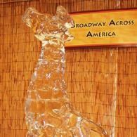 Golden statue before a “Broadway Across America” banner against a bamboo wall.