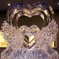 Crystal angel sculpture with wings beneath a heart-shaped arch, lit indoors