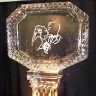 Octagonal engraved glass trophy with two figures etched on a dark background