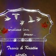 Decorative ice sculpted plaque with birds and flowers, engraved “endless love forever...” and names Travis & Kristin.