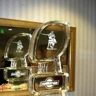 Two transparent ice sculptures with white logos, displayed indoors on a table