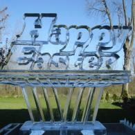 Clear ice sculpture reading “Happy Easter” outdoors against a blue sky.