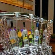 Four colorful liquor bottles displayed in an illuminated crystal ice bucket