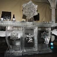 A silver bar display with Waterford crystal decor and a large floral centerpiece at an elegant event