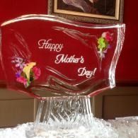 Red glass plaque engraved “Happy Mother’s Day” with floral accents on a decorative stand.