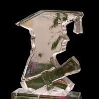Clear glass abstract ice sculpture shaped like a head figure with a graduation cap and tassel on a small base