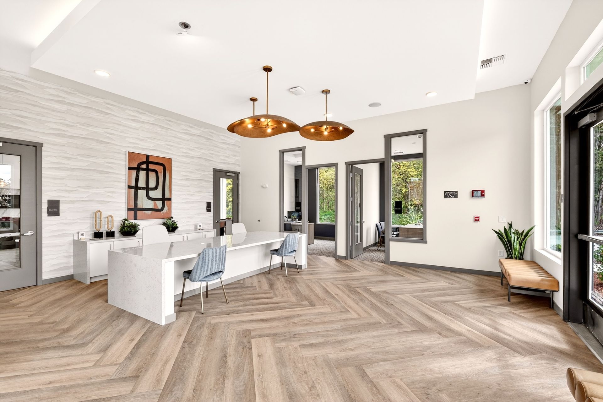 Modern open-plan living room with white walls, wood floors, dark windows, and copper pendant lights