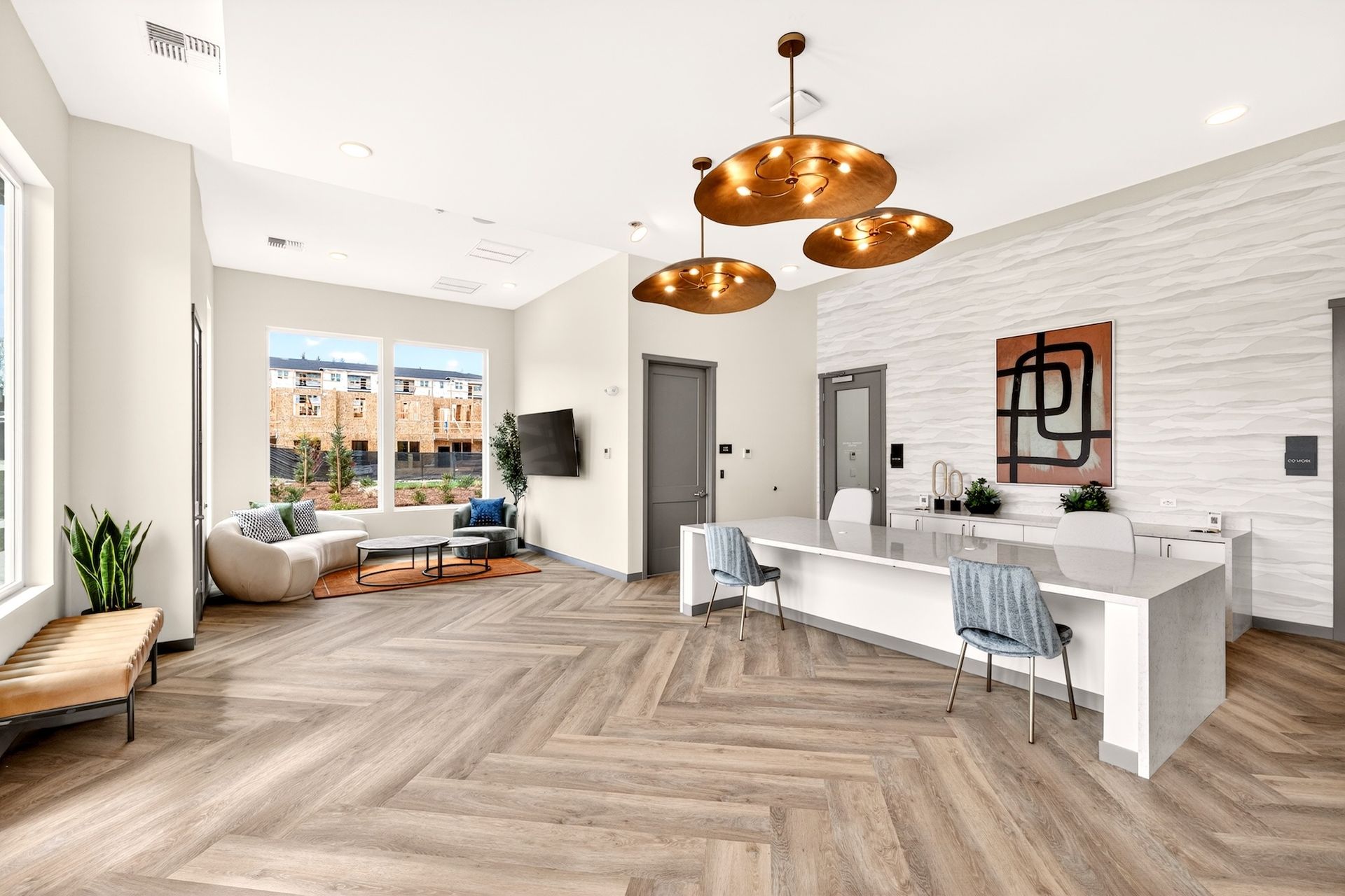 Modern open-plan living room with white walls, wood floors, sofas, and copper pendant lights