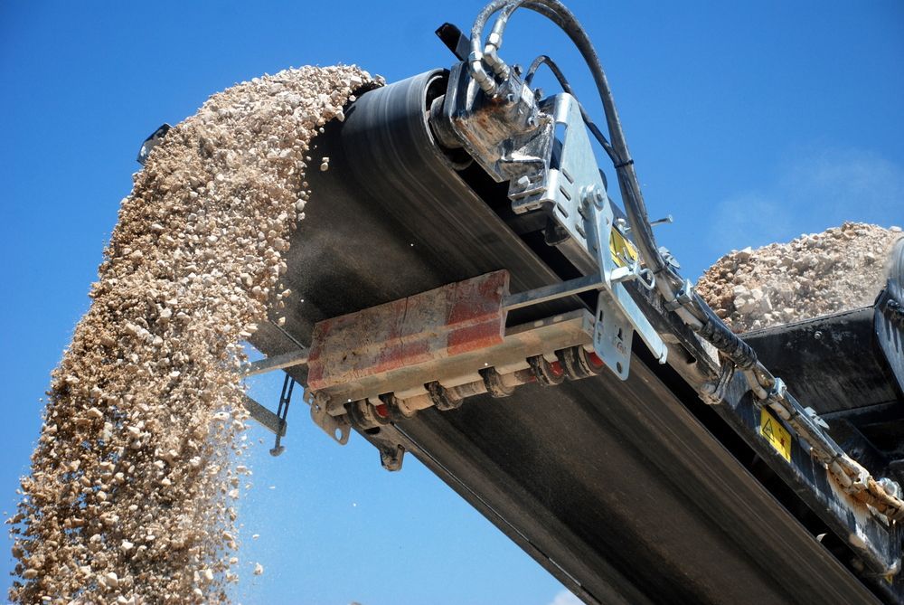 Conveyor Belt Dumping Gravel Against a Blue Sky — Boland Contracting In Wellington, NSW