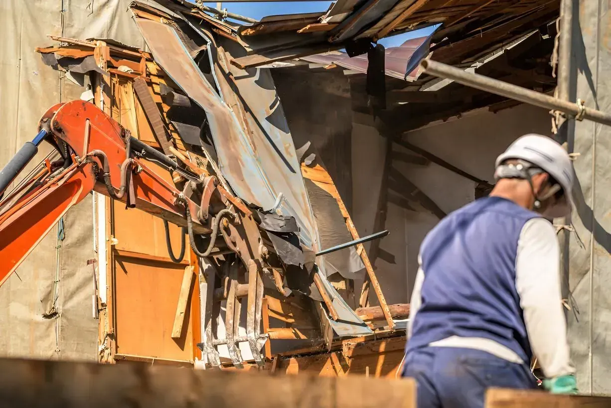 Demolition Site with Orange Excavator Tearing Down Building — Boland Contracting In Wellington, NSW