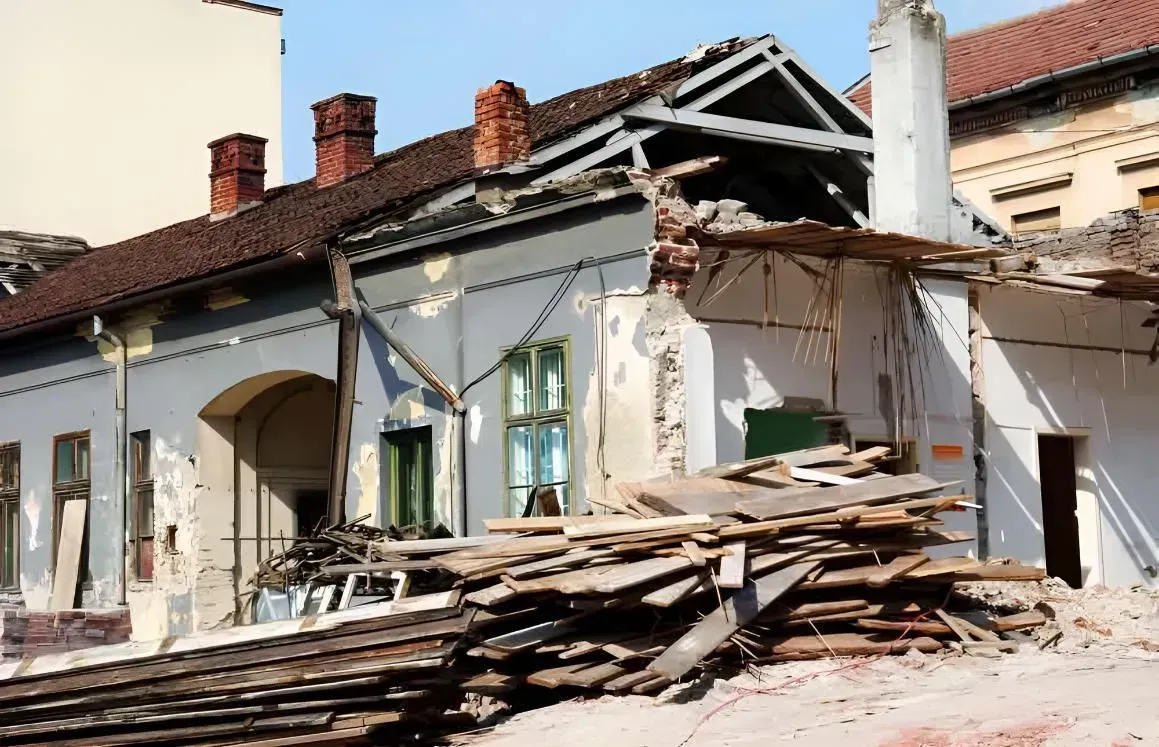 Damaged Building With a Collapsed Roof Debris Piled in Front — Boland Contracting In Wellington, NSW