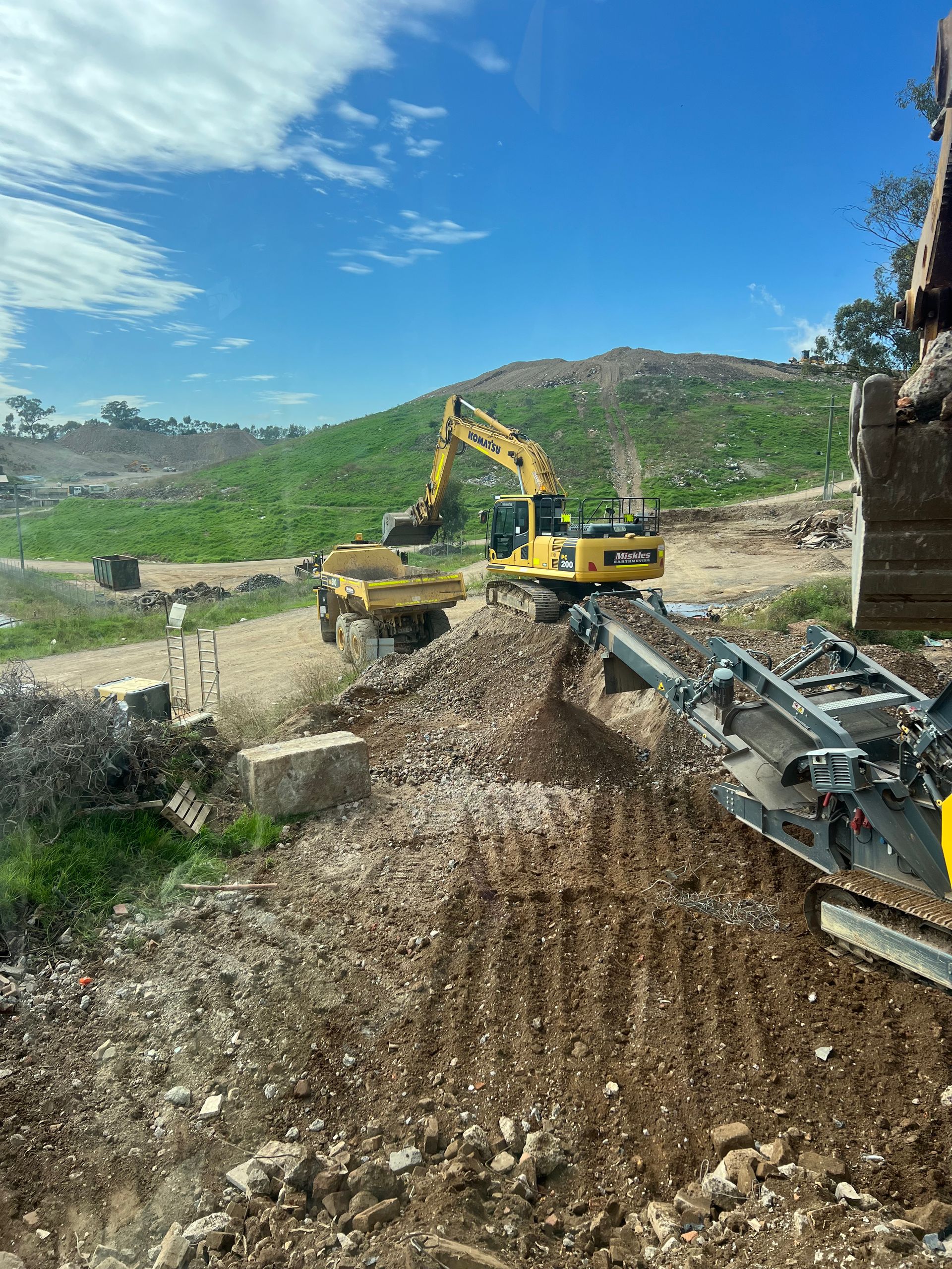 Excavator Loading a Dump Truck With Dirt and Rocks at a Construction Site — Boland Contracting In Wellington, NSW