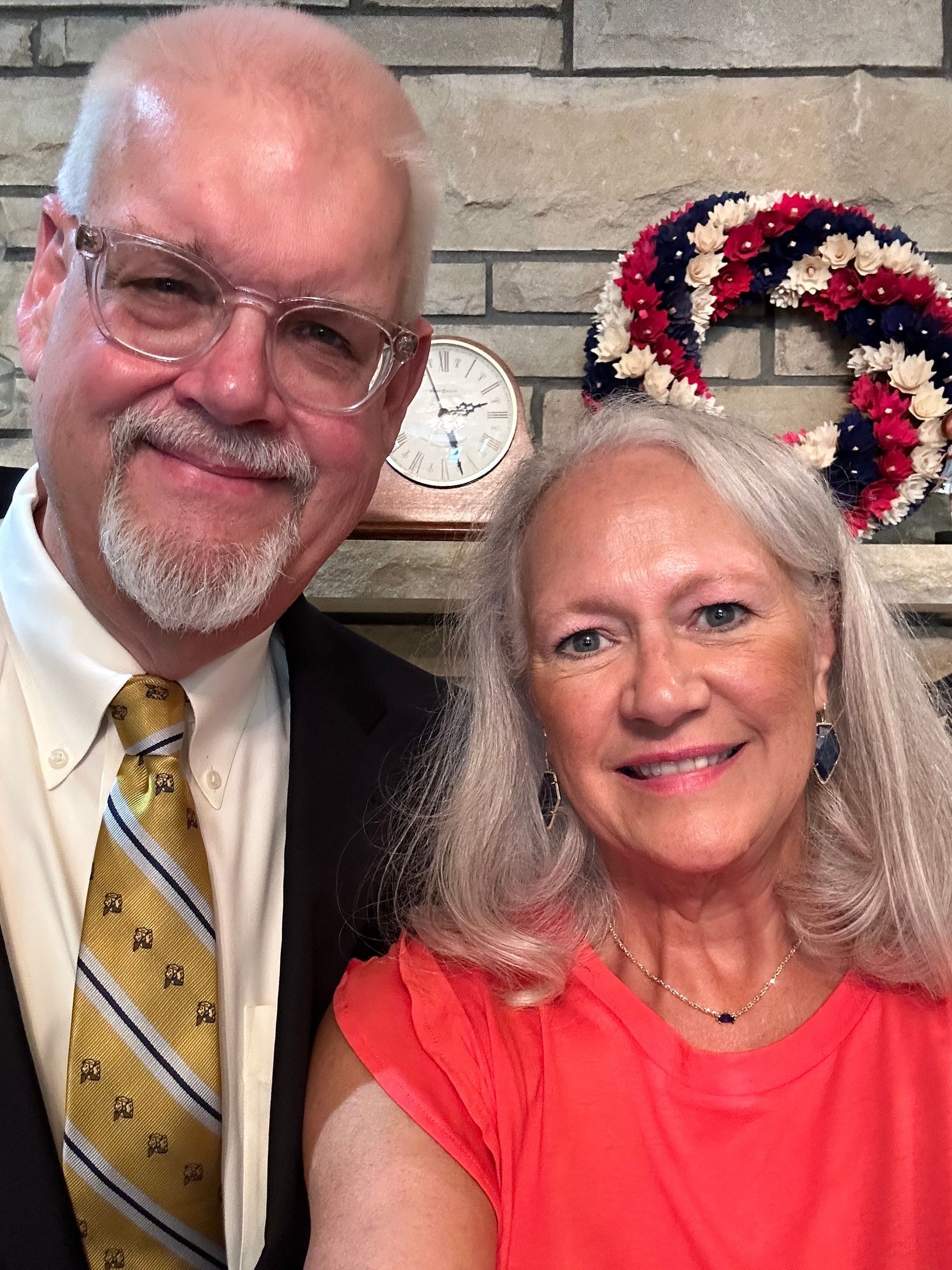 a man and a woman are posing for a picture in front of a fireplace .