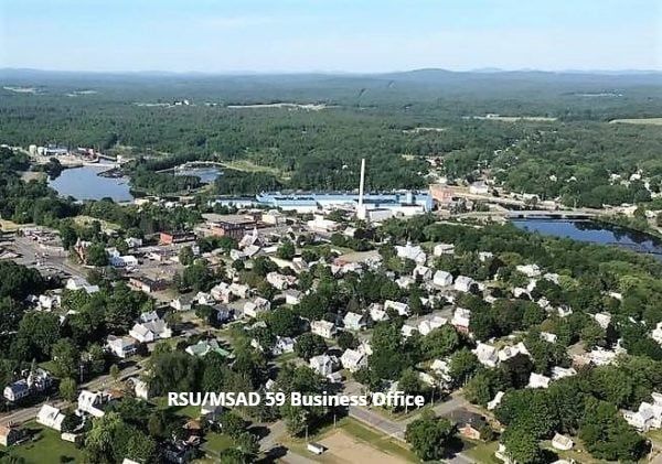 An aerial view of a small town surrounded by trees and a lake