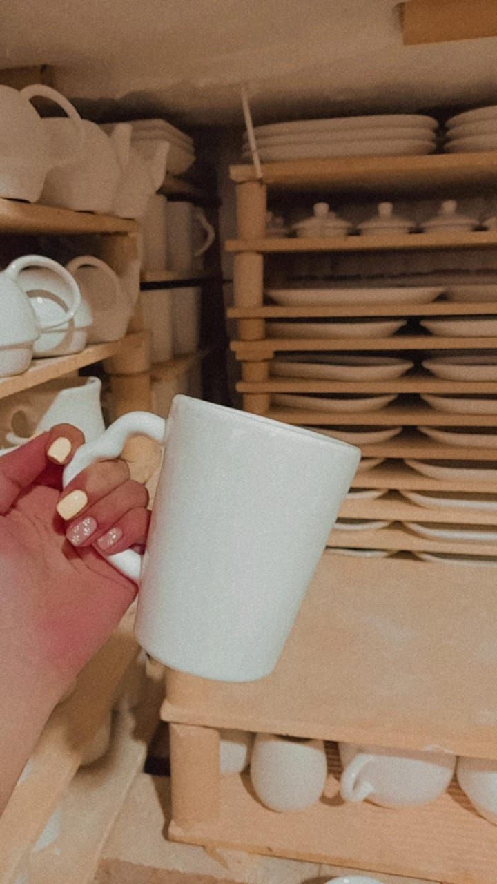 Taza azul con asa en forma de corazón sobre una encimera negra.