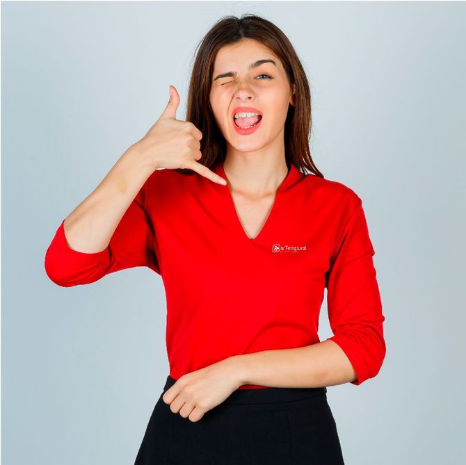 Una mujer con una camisa roja está haciendo una señal de
