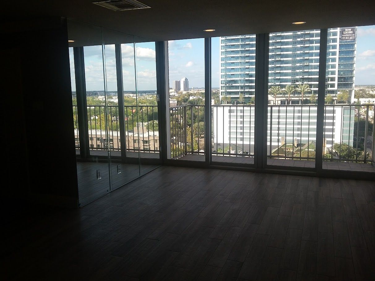 An empty room with lots of windows and a balcony