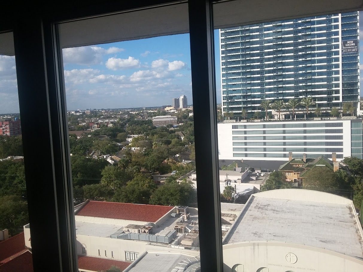 A view of a city from a window with a building in the background