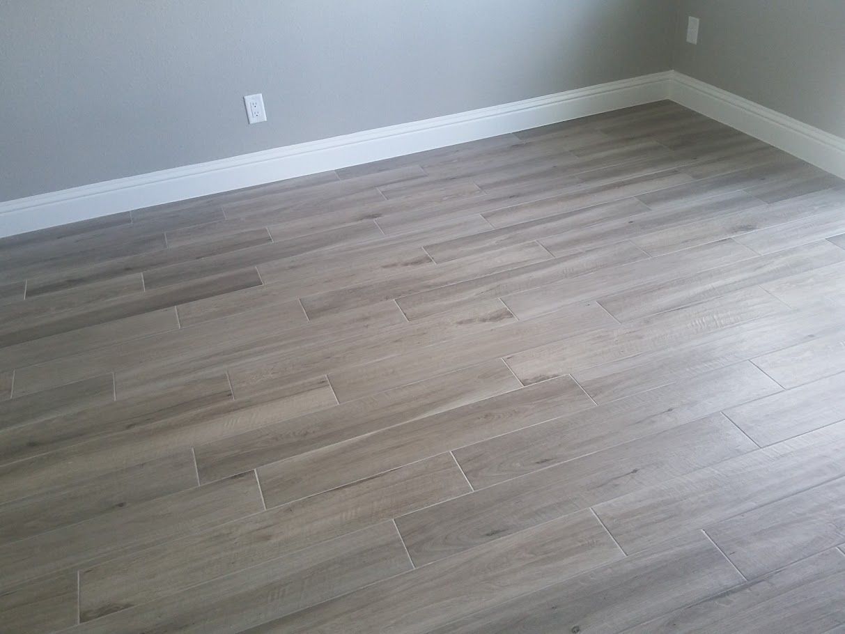 A room with a wooden floor and gray walls.