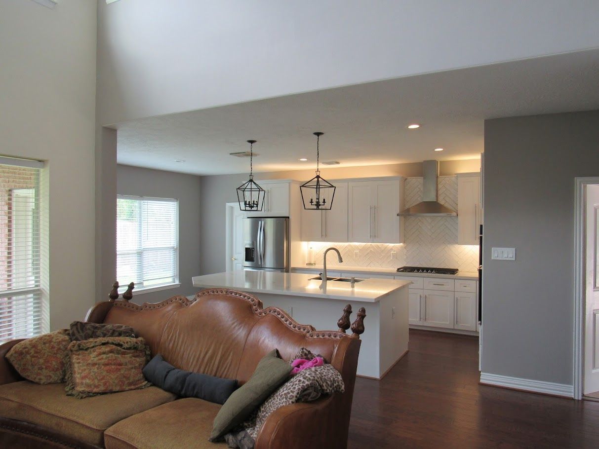 A living room with a couch and a kitchen in the background