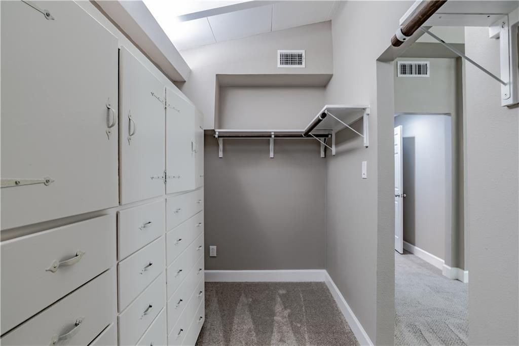 A walk in closet with lots of drawers and shelves