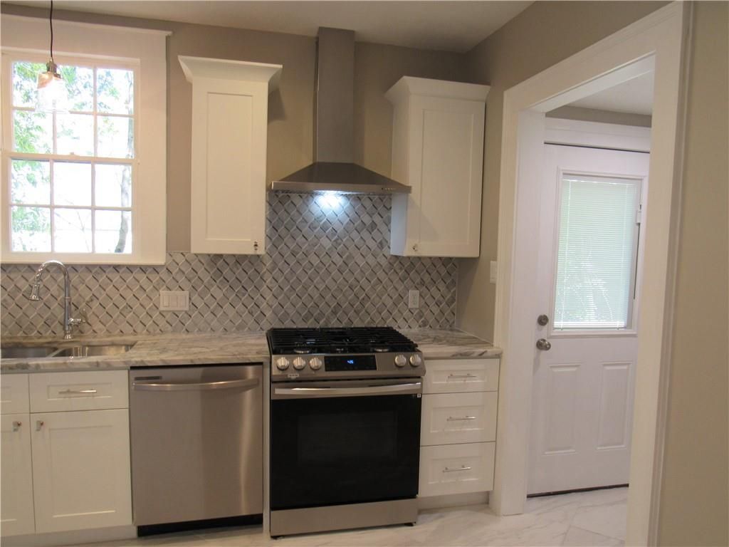A kitchen with stainless steel appliances and white cabinets