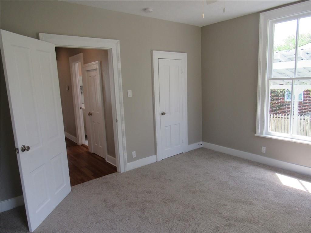 An empty room with a window and two doors