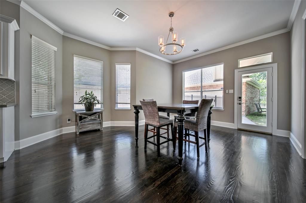 An empty dining room with a table and chairs and a chandelier.