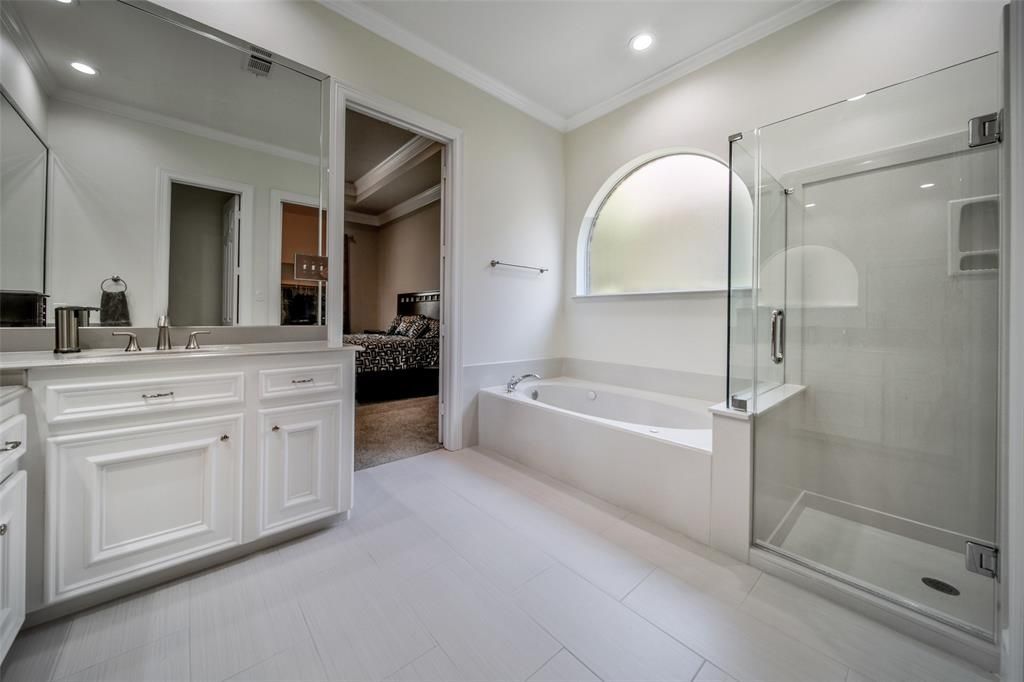 A bathroom with two sinks , a tub , and a walk in shower.