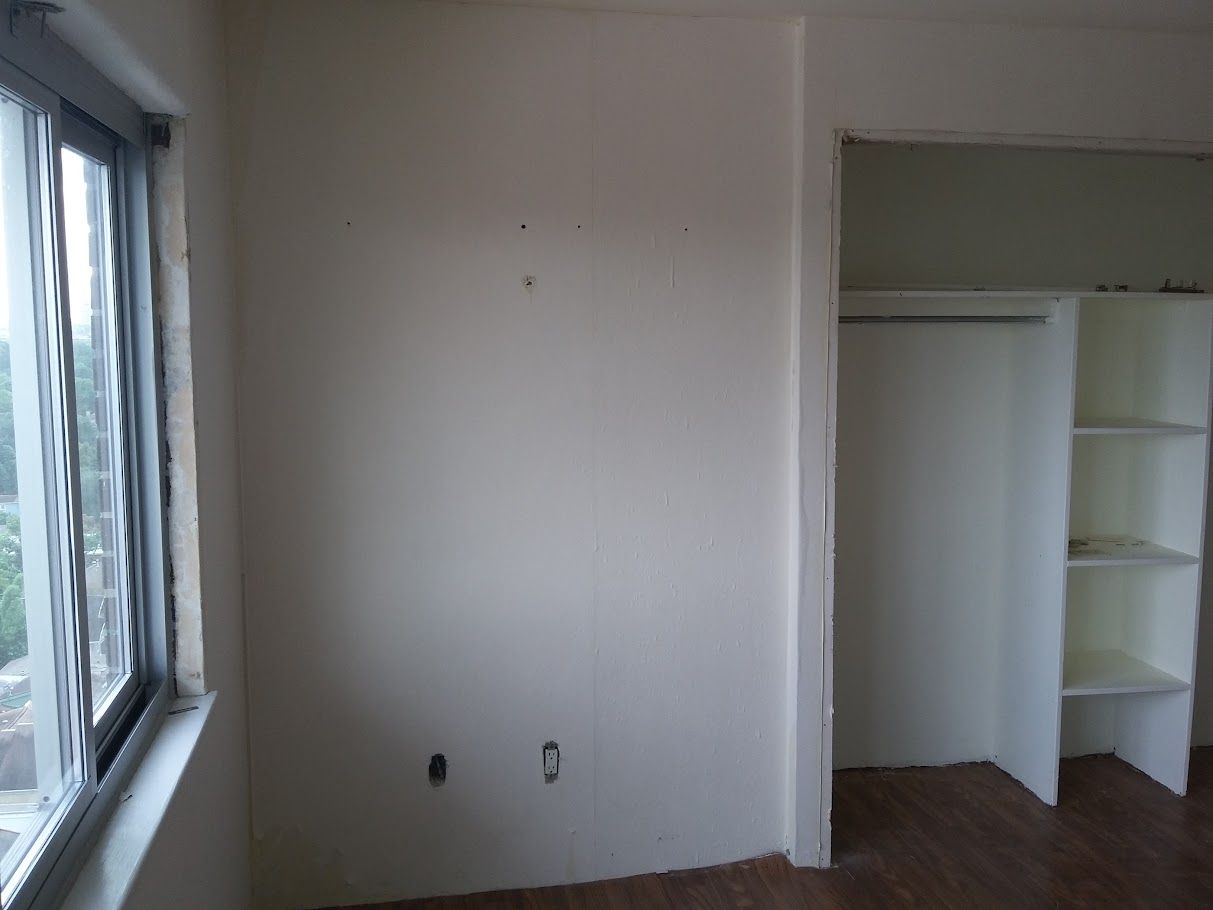 An empty room with a window and a closet