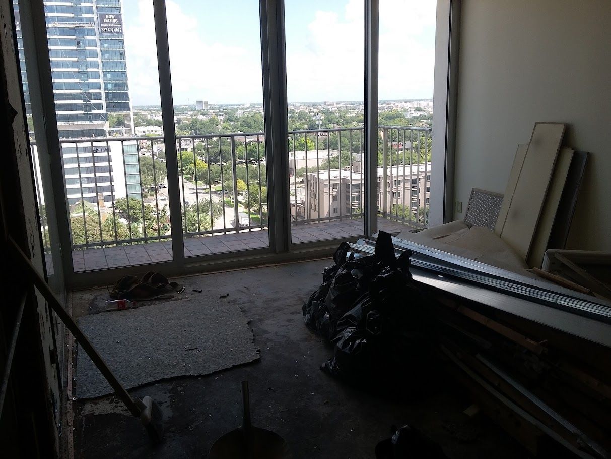 A room with a balcony and a view of a city