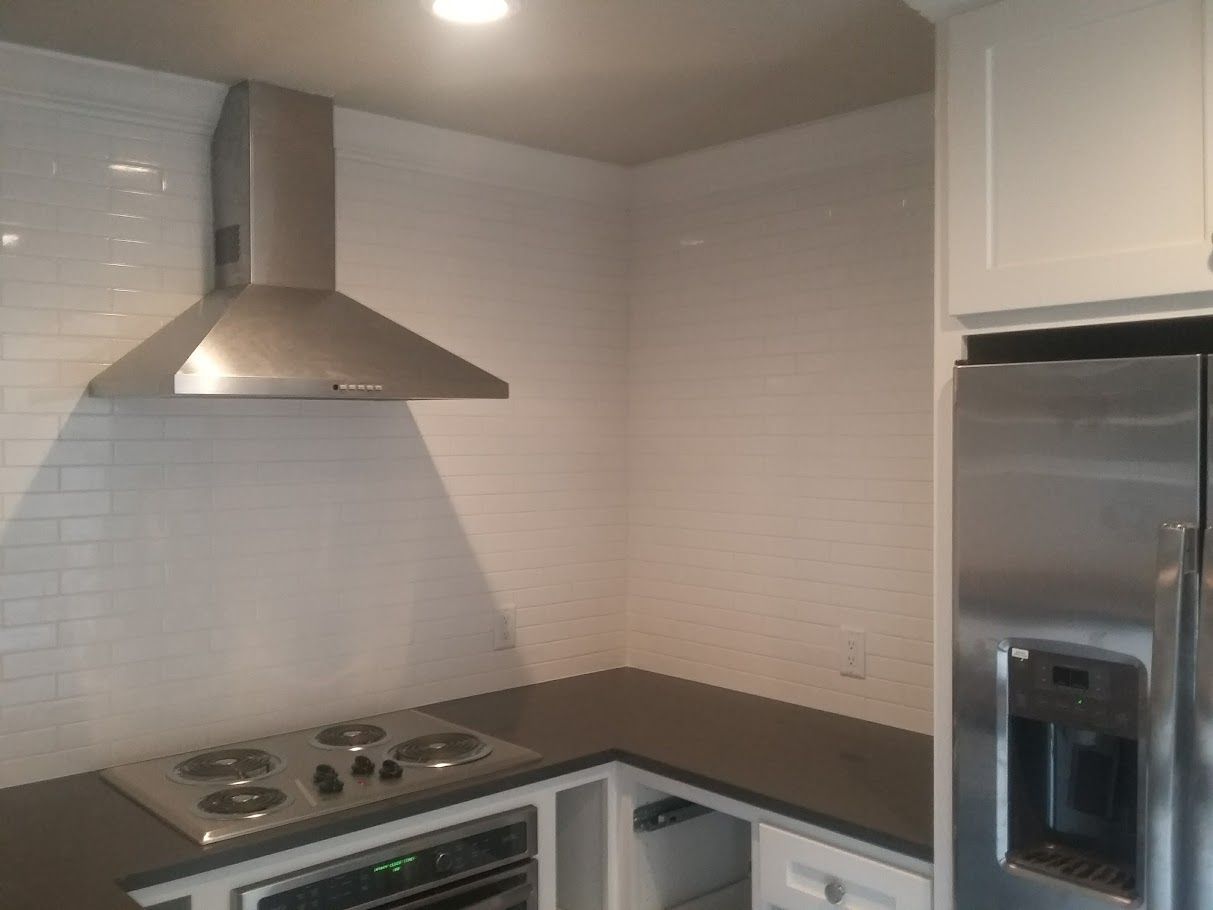 A kitchen with a stove top oven and a refrigerator