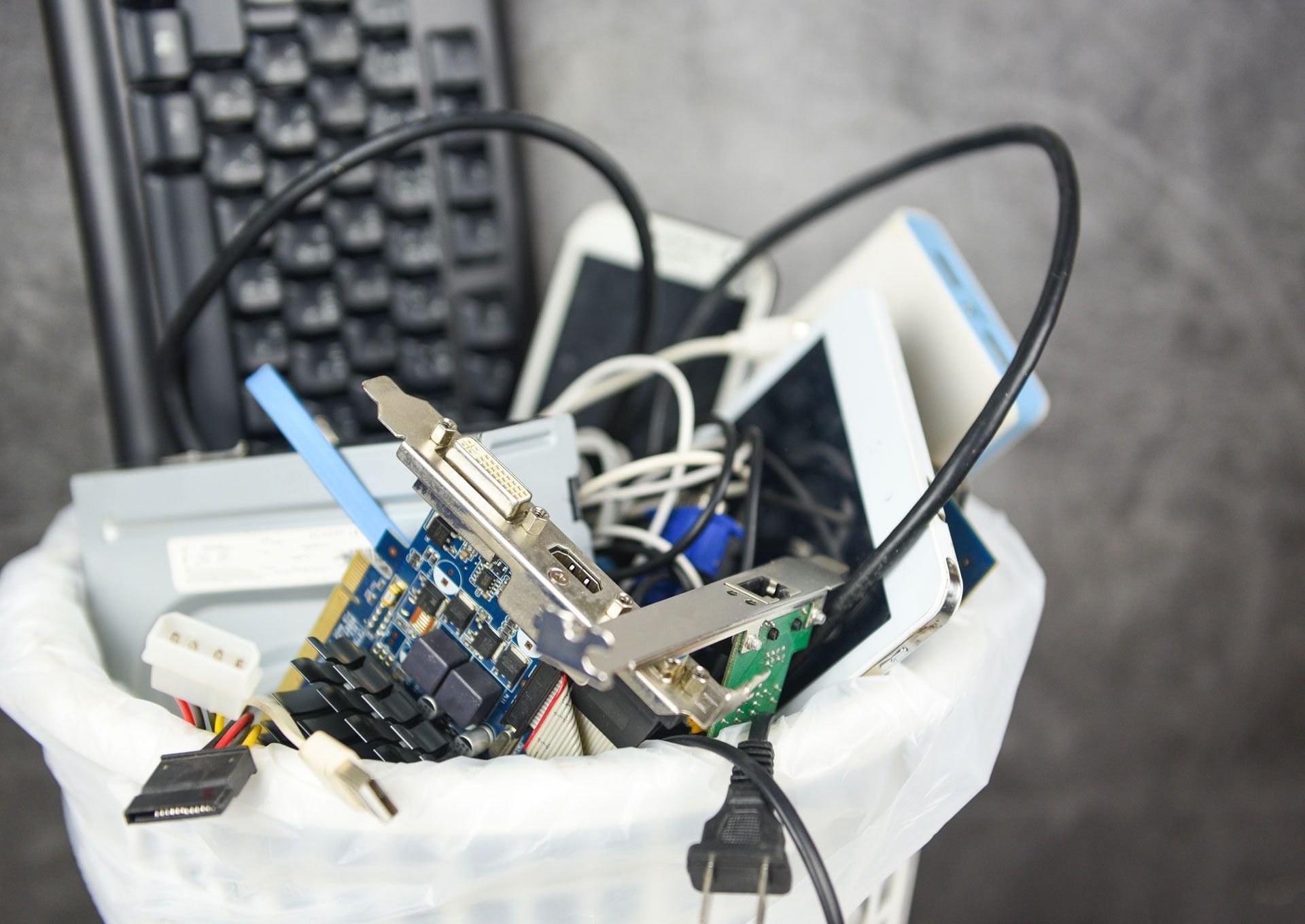 Close-up of tangled electronic wires and circuit boards inside a white plastic bag