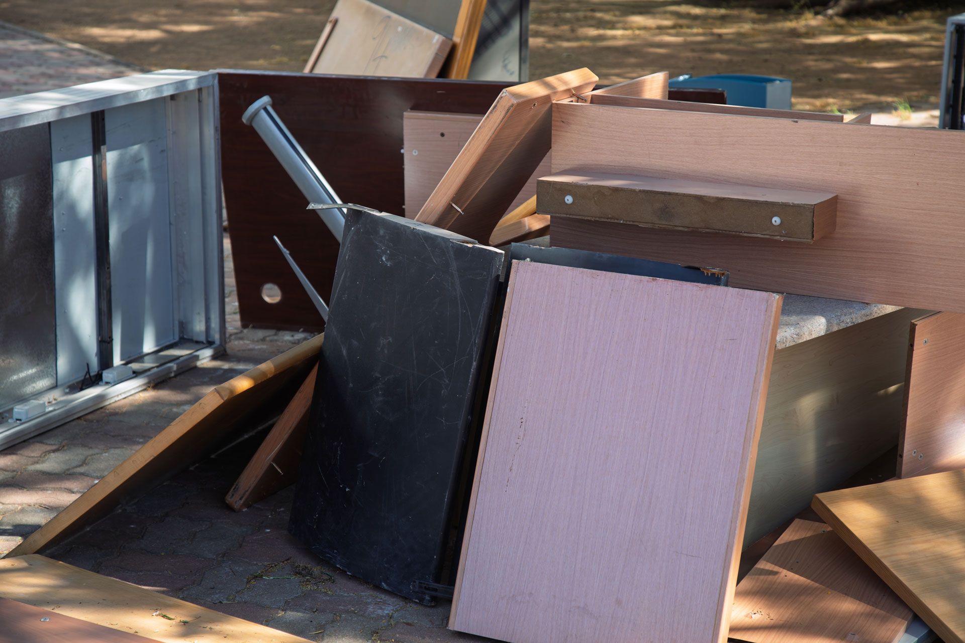 Pile of broken furniture and wood panels in a dumpster or construction debris pile
