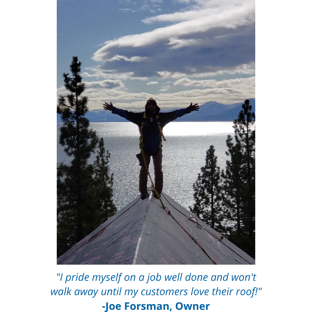Person standing on a roof with arms outstretched beside a lake and pine trees under a cloudy sky