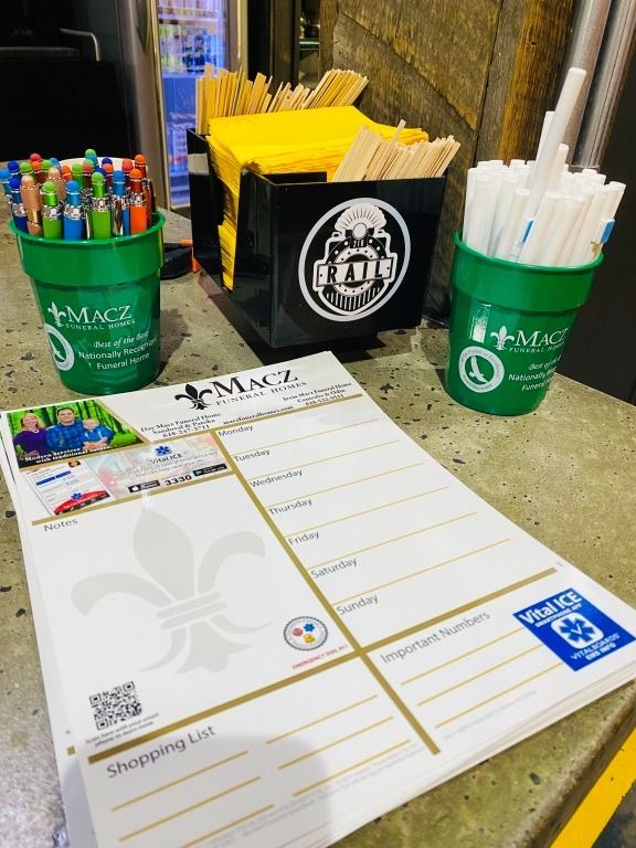 Stationery on counter: pens, stirrers, straws, shopping list pad with Macz logo.