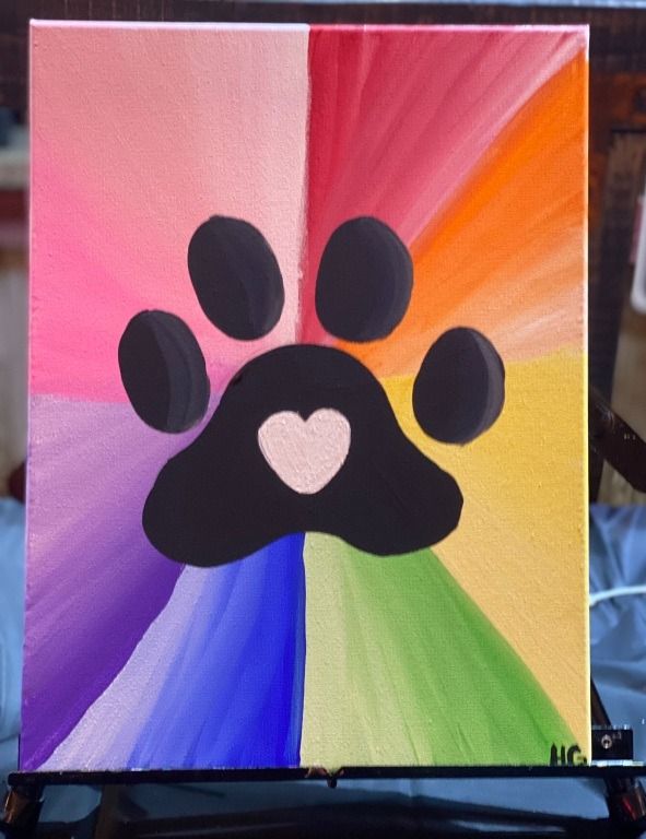Colorful paw print art with rainbow rays and heart.