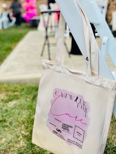 Tote bag with pink logo, reading 