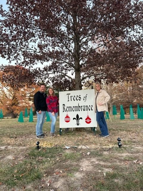 Three people stand by a 
