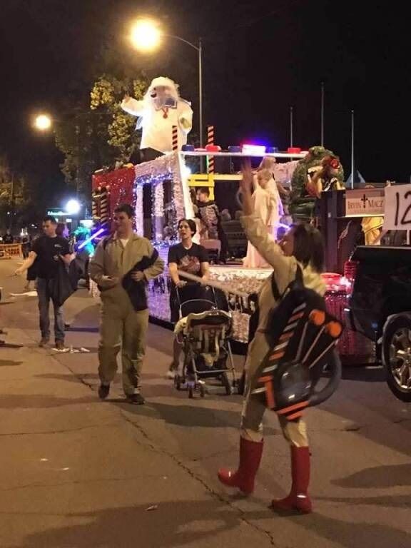 Ghostbusters parade float at night with people dressed as Ghostbusters.