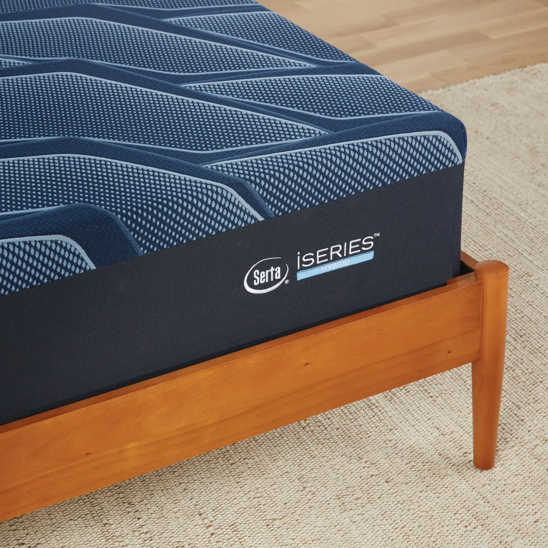 A blue mattress is sitting on top of a wooden bed frame.