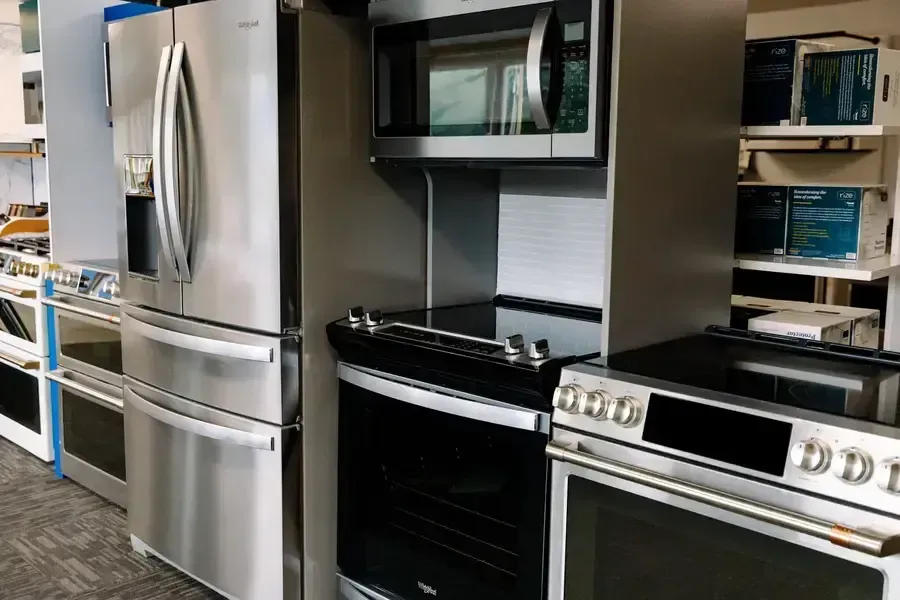 A kitchen with a refrigerator , microwave , oven and stove.