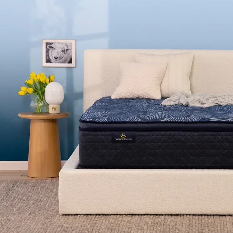 A bed with a blue mattress and white pillows
