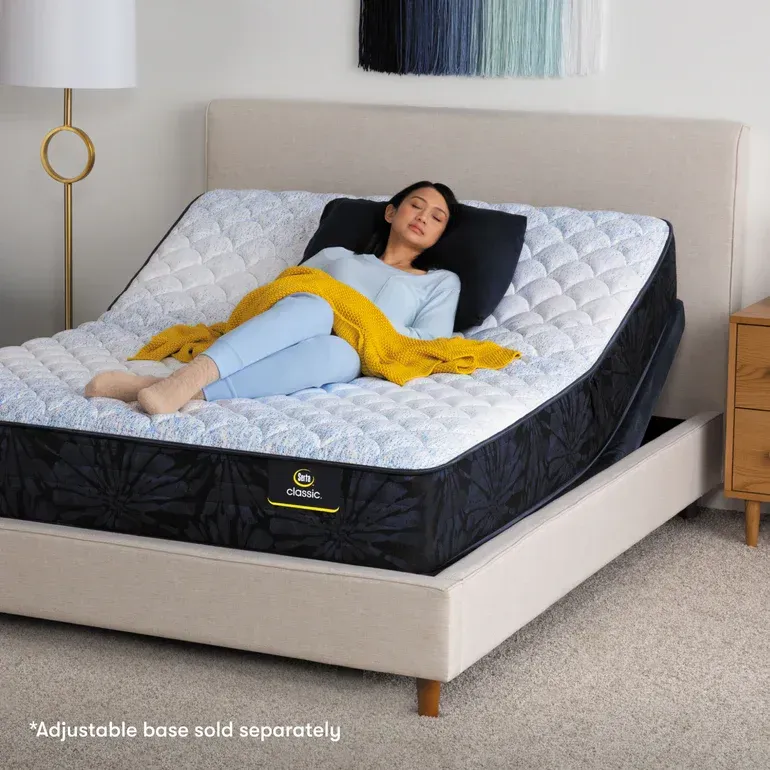 A woman is laying on an adjustable base mattress