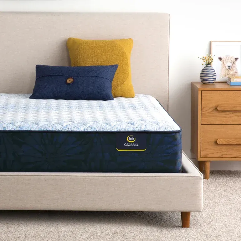 A bed with a mattress and pillows on it